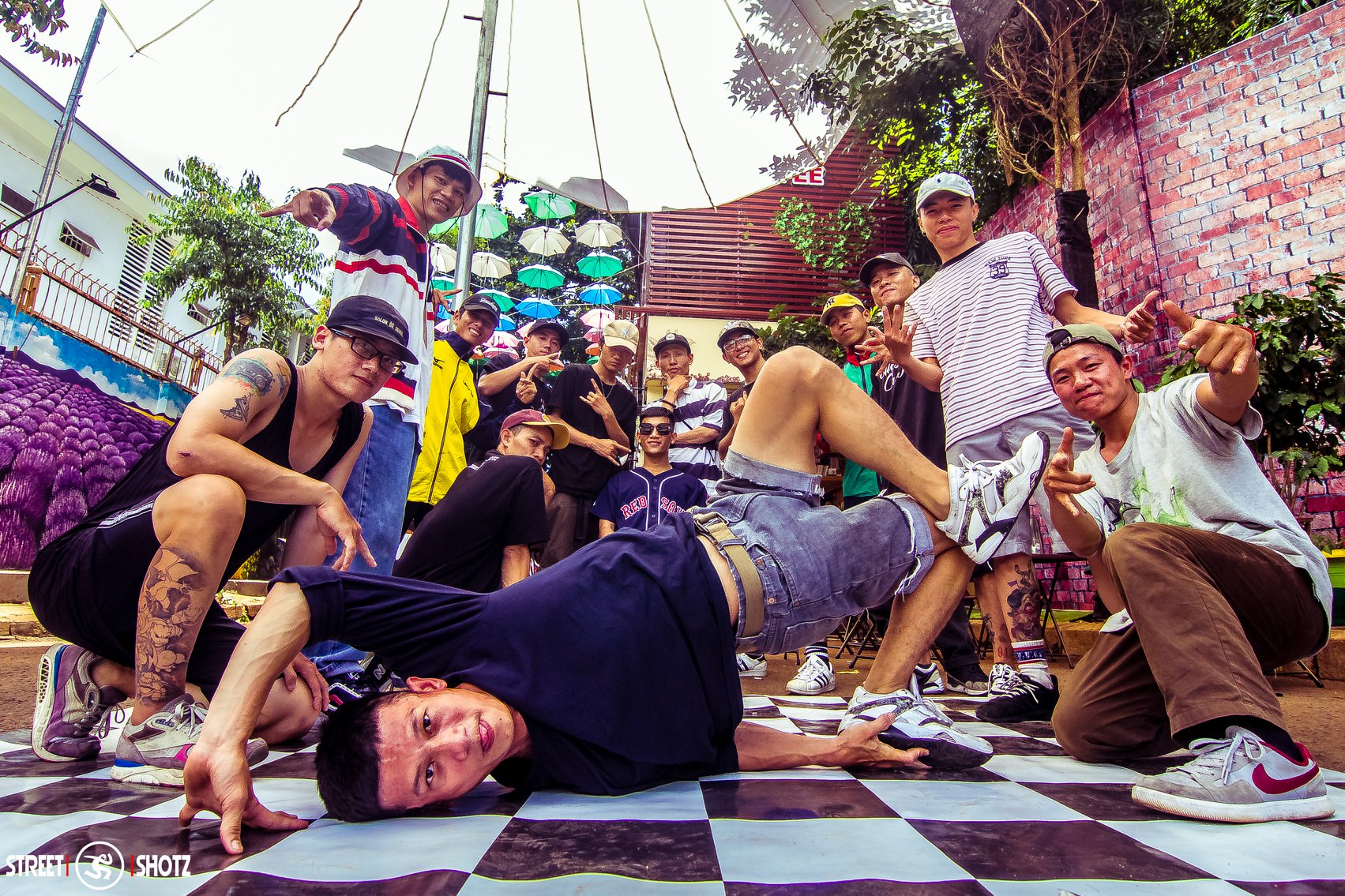 Breaking crew gathered at an outdoor session on a checkered dancefloor